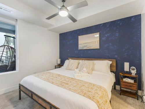 a bedroom with a large bed with a blue wall at Central SLC Apartment King Bed Gym Smart TV in Salt Lake City