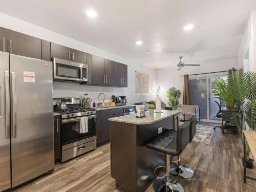 a kitchen with stainless steel appliances and a counter at Central SLC Apartment King Bed Gym Smart TV in Salt Lake City