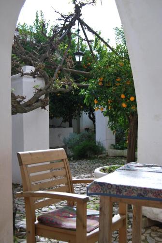 a table and a chair and an orange tree at Casa da Muralha de Serpa in Serpa