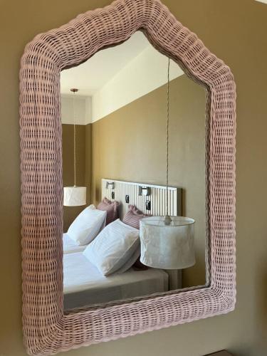 a wicker mirror in a bedroom with a bed at Kamara Apartments Marmari in Marmari