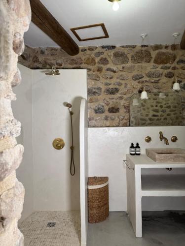 une salle de bain avec un lavabo et un mur en pierre dans l'établissement Mediterranean Suite in Ardèche, à Saint-Georges-les-Bains