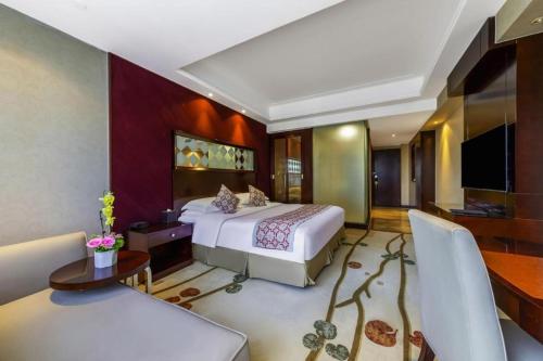a bedroom with a bed and a living room at Hohhot Hai Liang Plaza Hotel in Hohhot