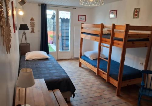 une chambre avec deux lits superposés et une lampe dans l'établissement Topette, à Barbâtre