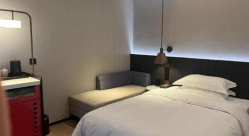 a hotel room with a bed and a chair at Movie Star Hotel in Guangzhou