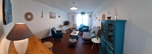 un salon avec une armoire bleue et des chaises bleues dans l'établissement Topette, à Barbâtre