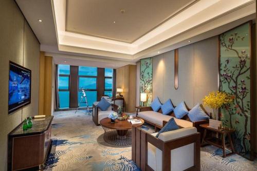 a living room with a couch and a tv at Dali Hotel in Dali