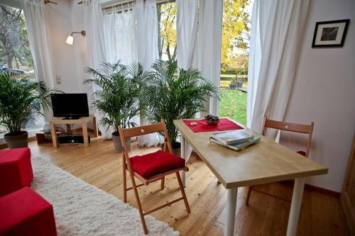 a living room with a table and chairs with plants at Ferienhaus Kastaniengrün in Worpswede