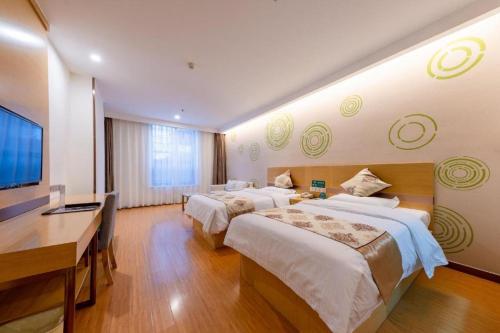 a hotel room with two beds and a desk and a television at GreenTree Inn Nantong University Industrial Expo City Express Hotel in Nantong