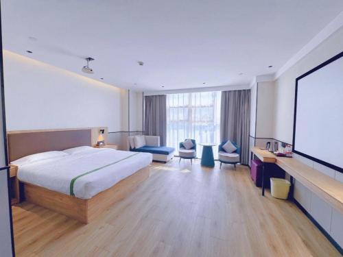 a hotel room with a bed and a projection screen at GreenTree Inn Nanjing Baijiahu in Nanjing