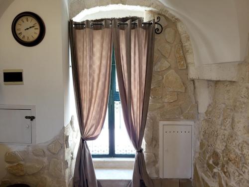 a window in a room with a clock on a wall at Dimora La Piana in Ostuni