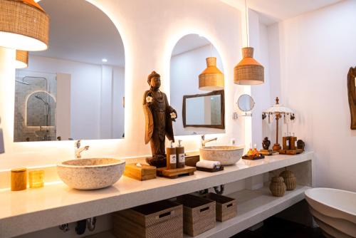 a bathroom with two sinks and a statue of a woman at Antana Hotel in Canggu