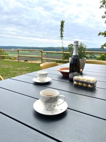 a table with two cups of coffee and a bottle of wine at Vila Vinita in Sveti Jurij ob Ščavnici