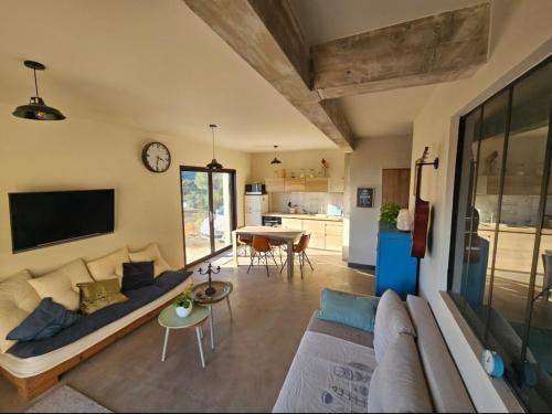 a living room with a couch and a table at Appartement en rez-de-jardin in La Valette-du-Var