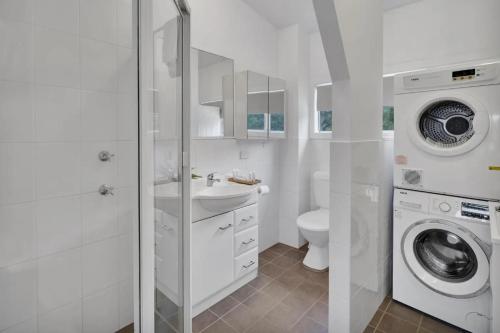 a white bathroom with a washing machine and a washer at Ingenia Holidays One Mile Beach in One Mile