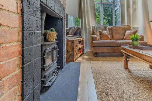 a living room with a brick fireplace and a couch at Lye Vally Headington- Oxford in Oxford