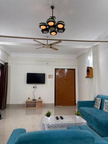 a living room with a blue couch and a tv at eVara homEs - Homestay Ghy in Guwahati