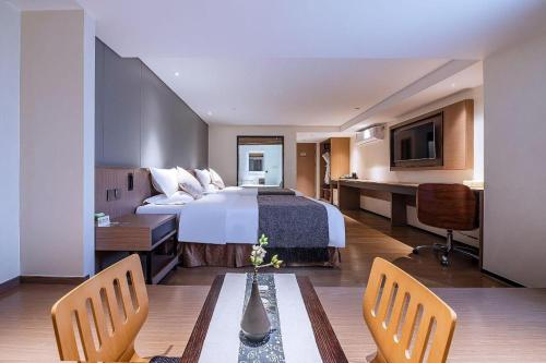 a hotel room with a bed and a table and chairs at Zhongshan Louis Hotel in Zhongshan