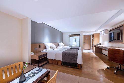 a hotel room with a large bed and a desk at Zhongshan Louis Hotel in Zhongshan