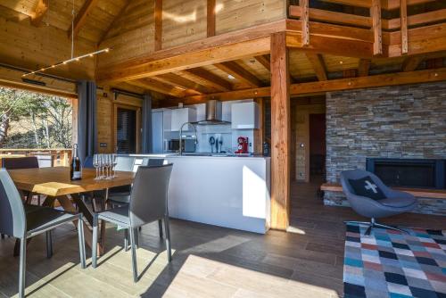 une cuisine et une salle à manger avec une table et des chaises dans l'établissement Les chalets perchés, à Muhlbach-sur-Munster