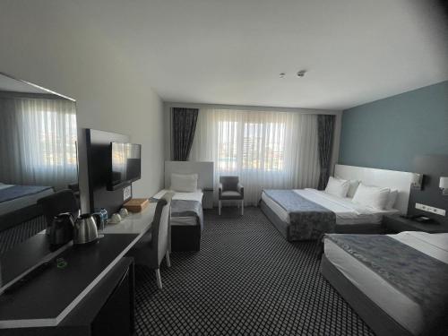 a hotel room with two beds and a television at Cavit Duvan Prestige Hotel in Edirne