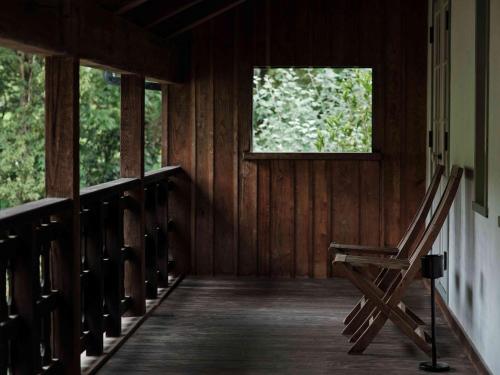 a rocking chair sitting on a porch of a cabin at HOTEL HOLIDAY HOME in Kyotango