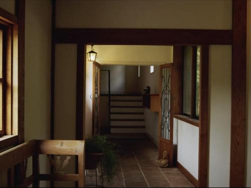 a hallway with a door leading to a room with stairs at HOTEL HOLIDAY HOME in Kyotango
