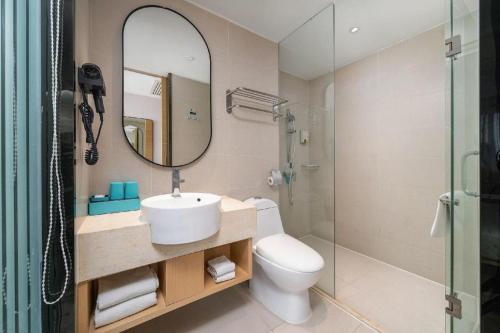łazienka z umywalką, toaletą i lustrem w obiekcie City Comfort Inn Dongguan Humen Wanda High-speed Railway Station Beizha w mieście Dongguan