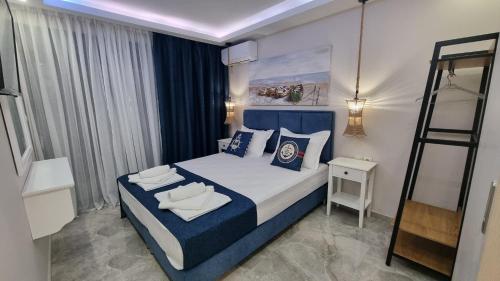 a bedroom with a blue and white bed and a ladder at Agia Lydia Sea View Suite House in Karianí