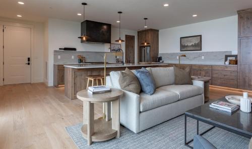 a living room with a couch and a kitchen at Newly Built - Teewinot at The Basin Luxury Suites in Driggs