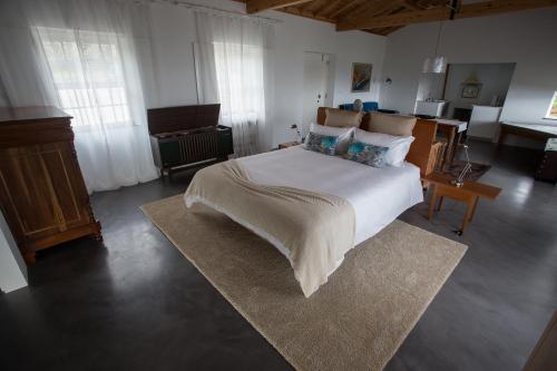 a bedroom with a large white bed with a rug at Pico da Vigia in Santa Bárbara