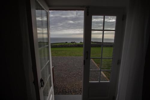 an open door with a view of a field at Pico da Vigia in Santa Bárbara