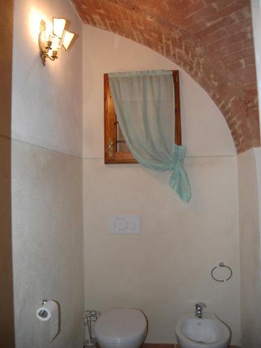 a bathroom with a sink and a toilet and a window at Monolocale a Buonconvento in Buonconvento