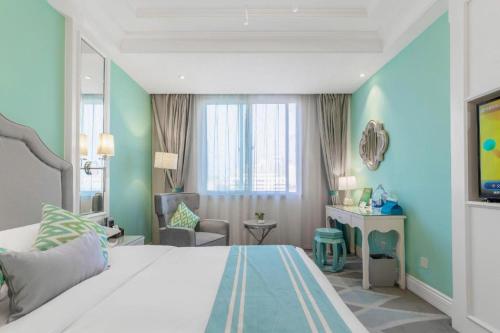 a bedroom with a bed and a desk in a room at Kunming Noah's Ark Hotel in Kunming