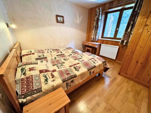 une chambre avec un lit avec une couette dessus dans l'établissement Résidence Lupins - 85m2 pour 5 personnes 3 chambre cuisine équipée à St Martin de Bellville MAE-4964, à Saint-Martin-de-Belleville