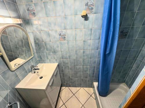 La salle de bains est pourvue d'un lavabo et d'un rideau de douche bleu. dans l'établissement Résidence Lupins - 85m2 pour 5 personnes 3 chambre cuisine équipée à St Martin de Bellville MAE-4964, à Saint-Martin-de-Belleville