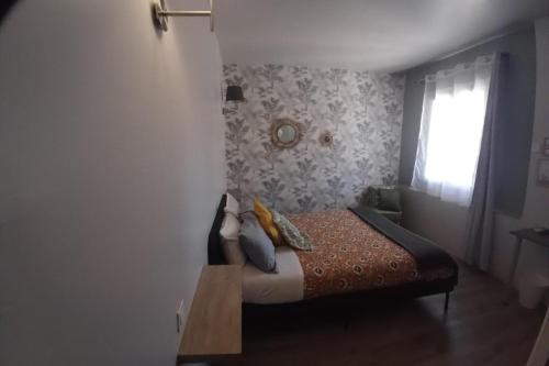 a small bedroom with a bed with a window at Hôtel Saint Florent in Orange