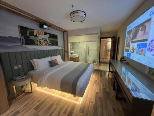 a bedroom with a large bed and a flat screen tv at Beijing Inner Mongolia Hotel Chaoyang in Beijing