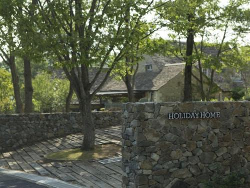 a stone wall with the holliday house sign on it at HOTEL HOLIDAY HOME in Kyotango