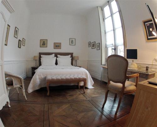 a bedroom with a large bed and a chair at Maison Colladon in Bourges
