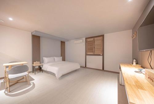 a bedroom with a bed and a desk and a chair at ZZAM Hotel in Jeonju