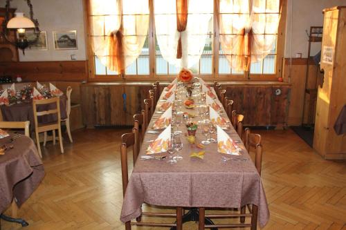 a long table in a room with chairs and a table with glasses at Hotel Restaurant Jura in Kerzers