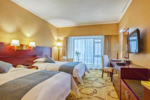 a hotel room with two beds and a television at Changchun Garden Hotel in Changchun