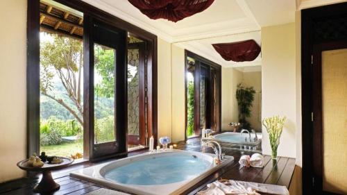 Un baño grande con bañera y una ventana grande en Anhera Suite & Spa, en Ubud