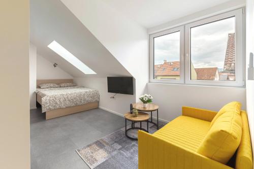 a living room with a yellow couch and a bed at House Pr'Španc in Ljubljana