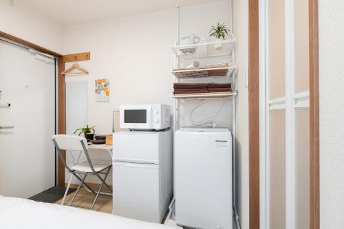a kitchen with a white refrigerator and a microwave at Parkside Shinjuku Tokyo in Tokyo