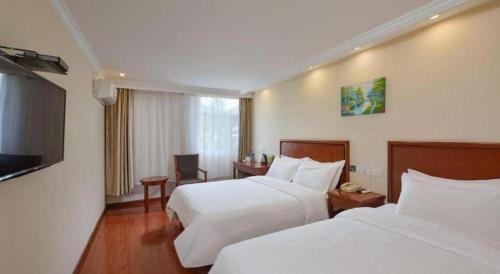 a hotel room with two beds and a flat screen tv at GreenTree Inn Nanjing Forestry University National Exhibition Center Express Hotel in Nanjing