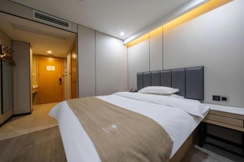 a large bedroom with a large bed and a bathroom at GreenTree Inn Shanghai Railway Station Macao Road in Shanghai