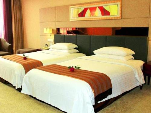 two beds in a hotel room with white sheets at Xian Union Alliance Atravis Executive Hotel in Xi'an