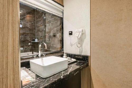 a bathroom with a white sink and a mirror at Xian Union Alliance Atravis Executive Hotel in Xi'an