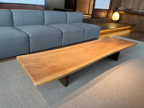 a living room with a couch and a wooden coffee table at 古民家ラグジュアリーホテル 金井西洋館 in Sado